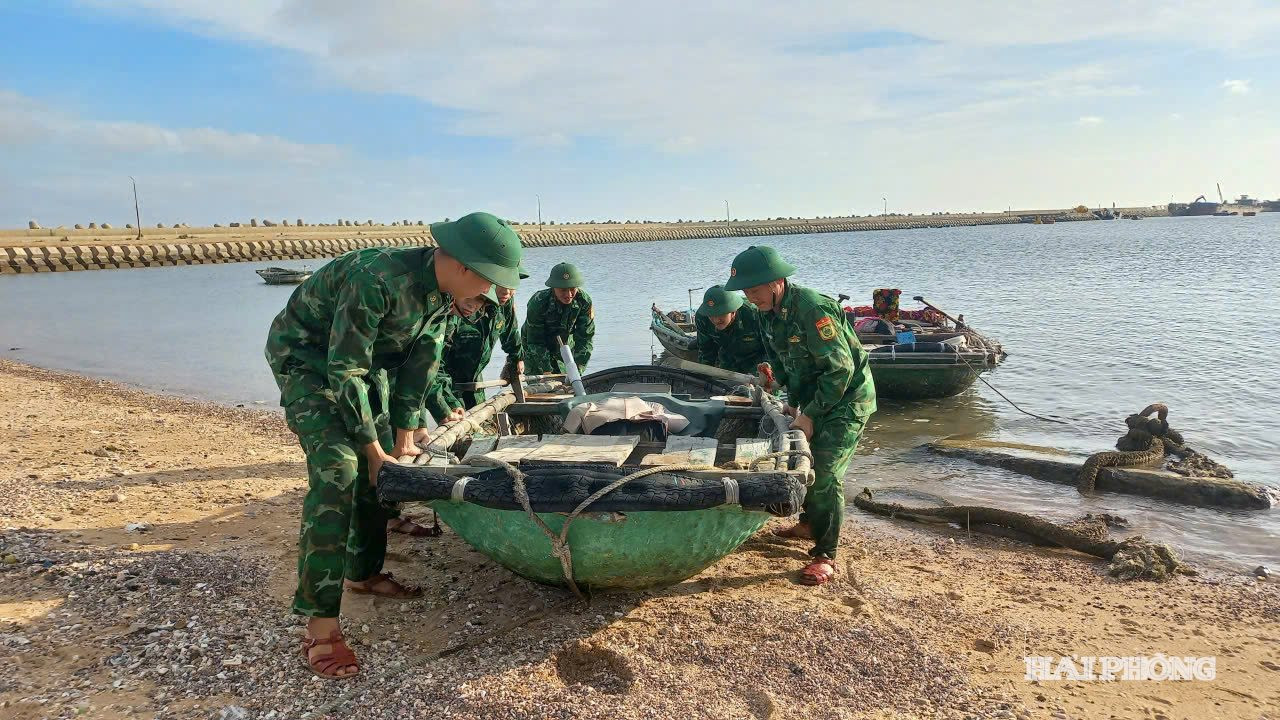 Cán bộ, chiến sĩ Đồn Biên phòng Bạch Long Vĩ giúp ngư dân kéo phương tiện lên bờ để tránh trú bão