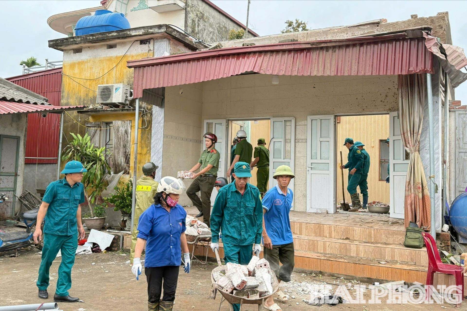 Các lực lượng xã Tân Minh tham gia giúp các hộ dân khắc phục hậu quả do dông lốc gây ra.