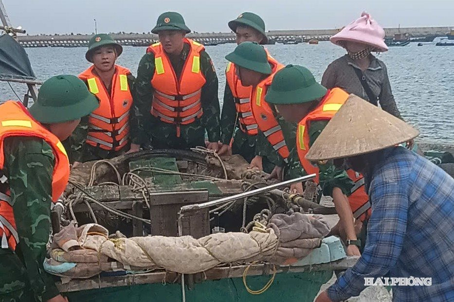 Cán bộ, chiến sĩ Đồn Biên phòng Bạch Long Vĩ hỗ trợ ngư dân đưa phương tiện lên bờ