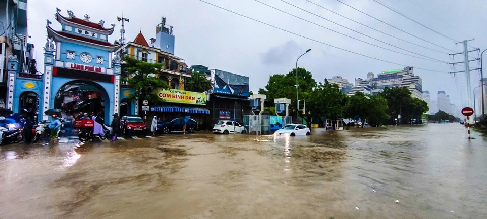 Người dân chật vật di chuyển qua điểm ngập. (Ảnh: Hoài Nam/Vietnam+)