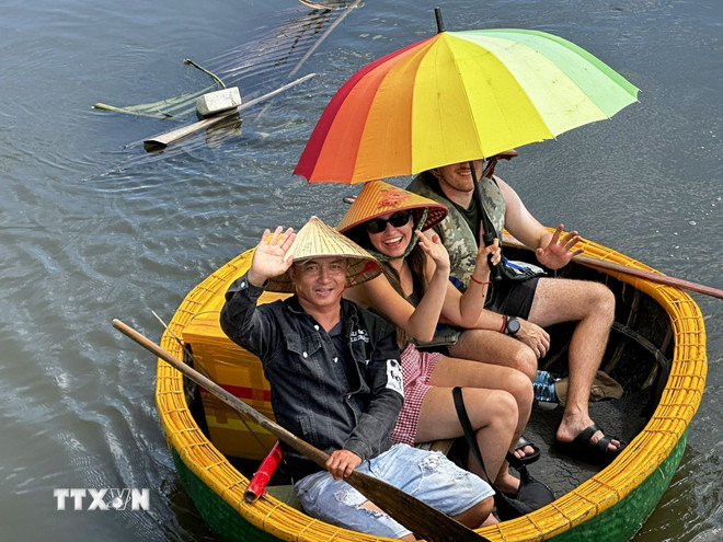 Khách du lịch quốc tế hào hứng khi được đi thuyền thúng tại làng du lịch Cẩm Thanh, phường Hội An Đông, thành phố Đà Nẵng. (Ảnh: Trần Lê Lâm/TTXVN) ttxvn-lang-cam-thanh-da-nang-4.jpg