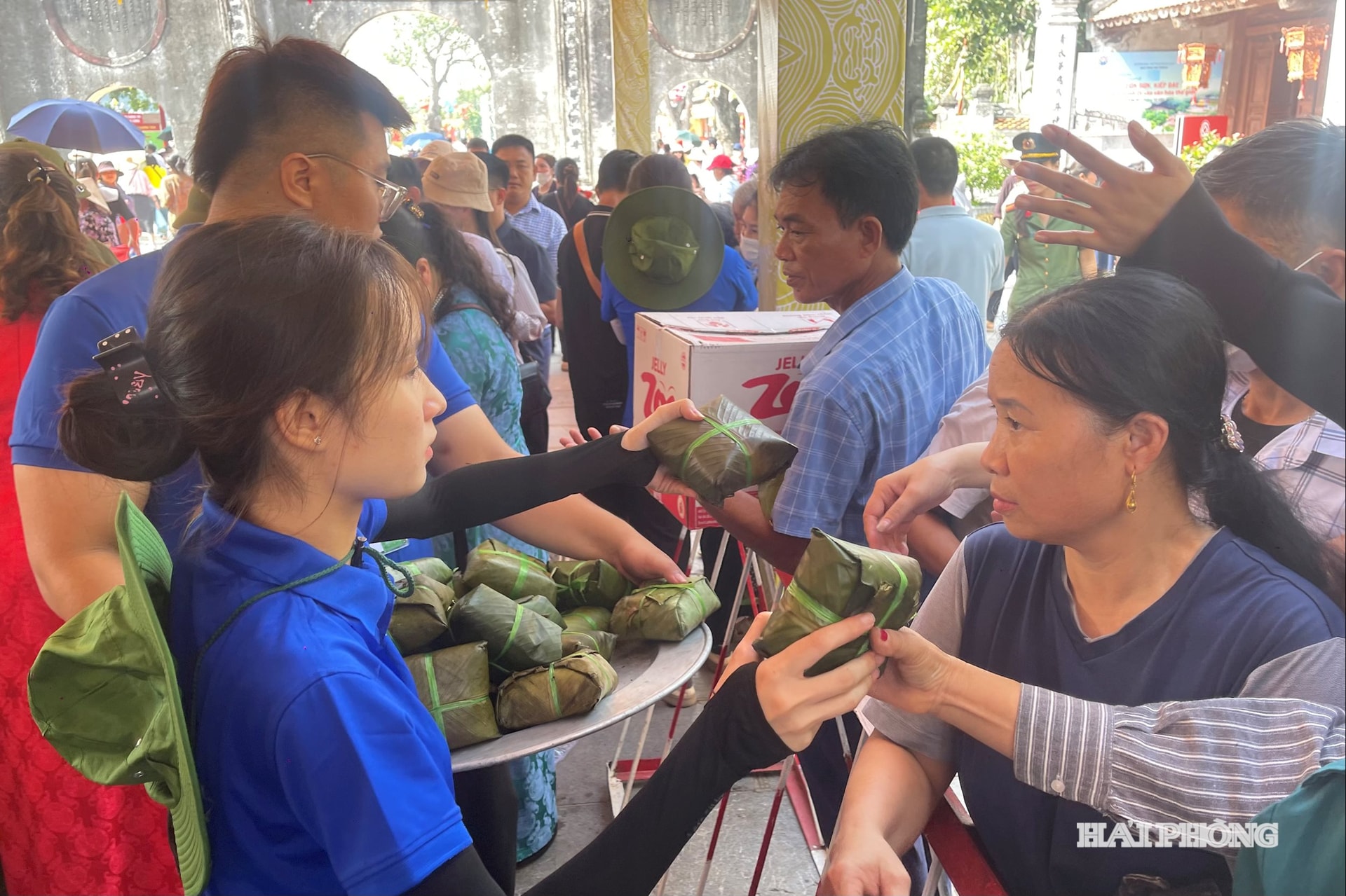 Tình nguyện viên hỗ trợ phát lộc cho người dân tới dâng hương Anh hùng dân tộc Trần Hưng Đạo tại đền Kiếp Bạc.