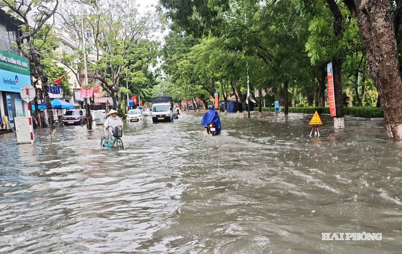 Tran Hung Dao-gatan är djupt översvämmad, vilket orsakar svårigheter för fordon.