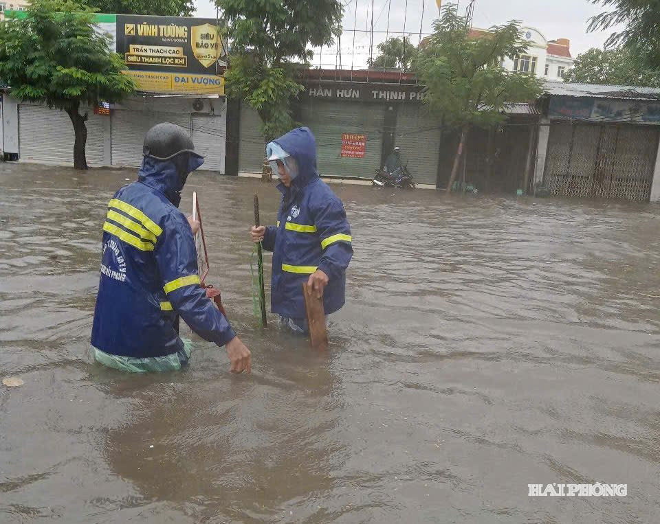 Công nhân Công ty TNHH Một thành viên Thoát nước Hải Phòng mở nắp các hố ga để tăng khả năng tiêu thoát nước.
