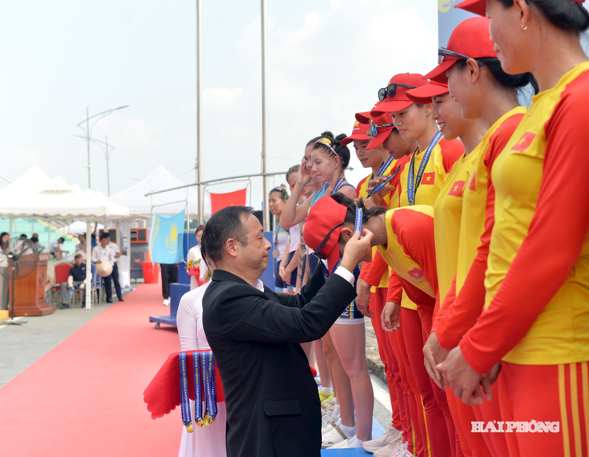 Ông Chen Chunxin, Chủ tịch Liên đoàn Rowing Châu Á trao huy chương vàng tặng các tuyển thủ nữ Việt Nam nội dung thuyền 8 người