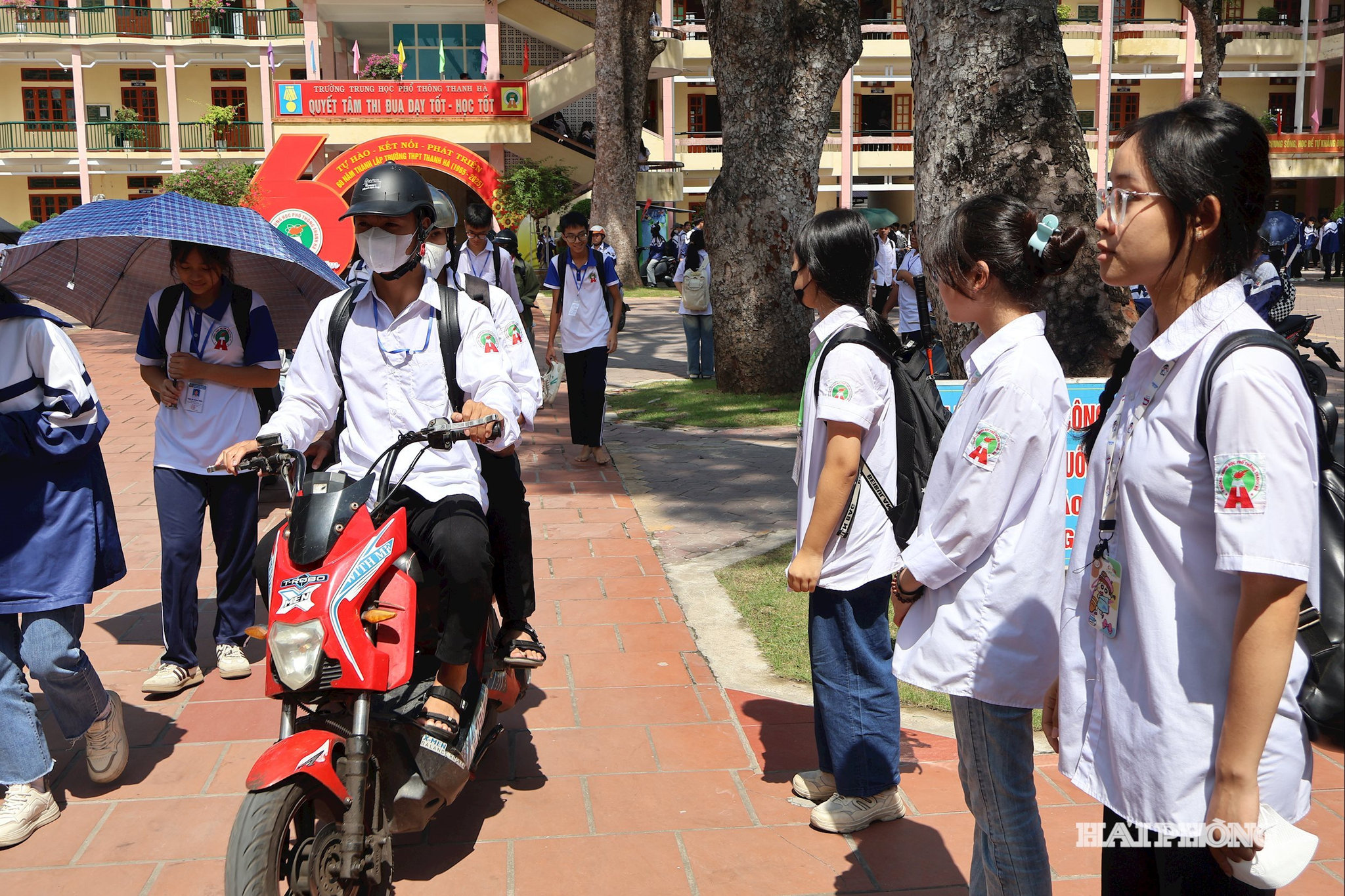Thành viên Đội Cờ đỏ luân phiên đứng trực tại cổng trường trước và sau mỗi buổi học để hướng dẫn, điều tiết giao thông.