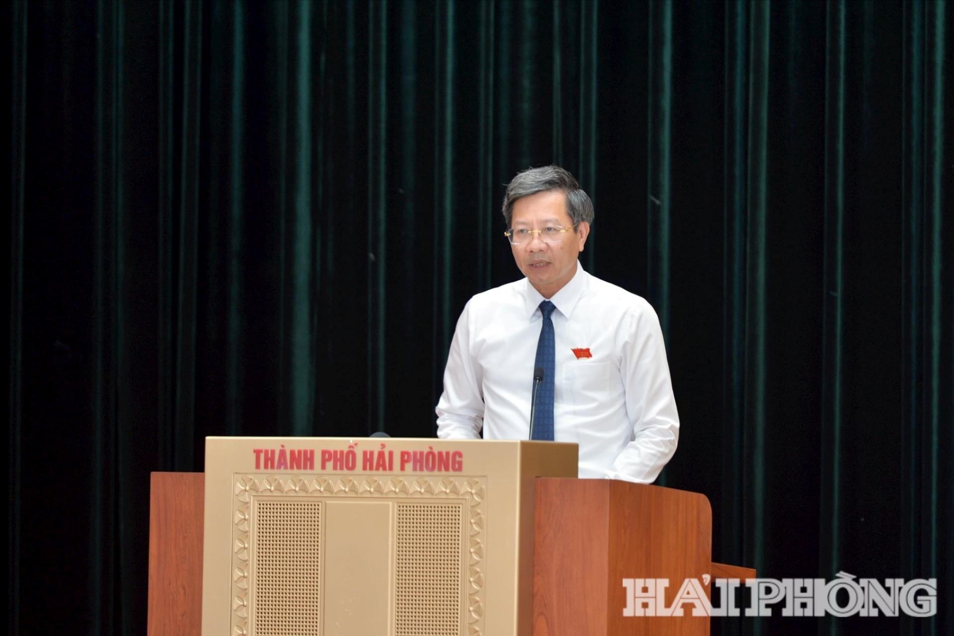 Đồng chí Lê Anh Quân, Uỷ viên Ban Thường vụ Thành uỷ, Phó chủ tịch Thường trực UBND thành phố đọc tờ trình tại kỳ họp. Ảnh: PHAN TUẤN