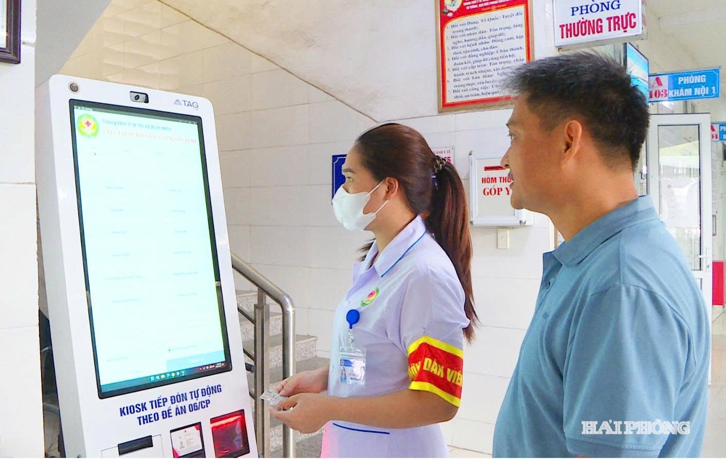 Personalen på Kinh Mon Medical Center vägleder patienter till att registrera sig för läkarundersökning via elektronisk kiosk