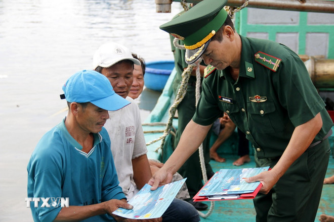 Cấp phát tài liệu chống khai thác IUU cho ngư dân. (Ảnh: Hồng Hiếu/TTXVN) ttxvn-khai-thac-iuu.jpg