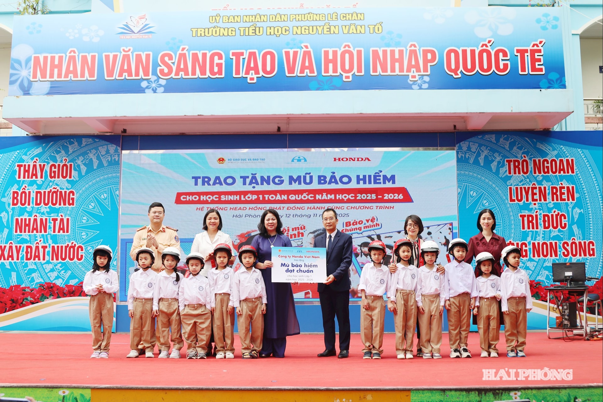 Đại diện Công ty Honda Việt Nam tại Hải Phòng (HEAD Hồng Phát) trao biểu trưng tặng mũ bảo hiểm học sinh lớp 1 Trường iểu học Nguyễn Văn Tố.
