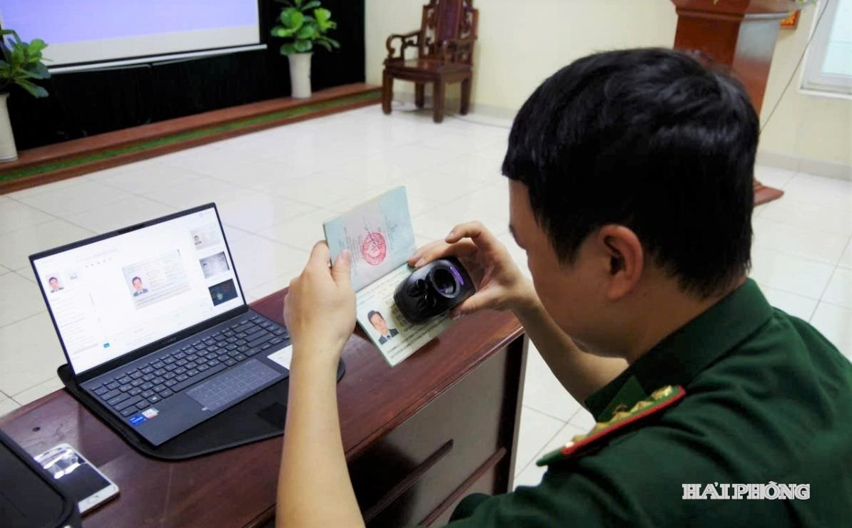 Cán bộ Biên phòng cửa khẩu cảng Hải Phòng dùng máy soi chiếu kiểm tra hộ chiếu thuyền viên nước ngoài nhập cảnh vào Việt Nam qua cảng