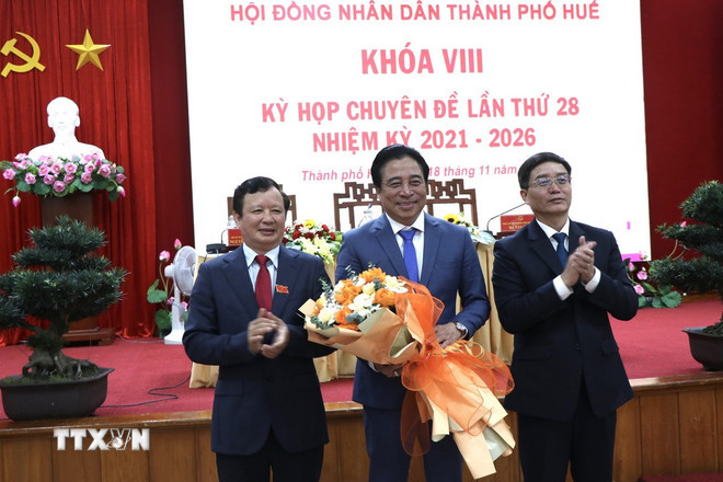 Tặng hoa chúc mừng Tân Chủ tịch Ủy ban Nhân dân thành phố Huế Nguyễn Khắc Toàn. (Ảnh: Mai Trang/TTXVN) ttxvn-ong-nguyen-khac-toan-duoc-bau-giu-chuc-chu-tich-ubnd-thanh-pho-hue-2.jpg