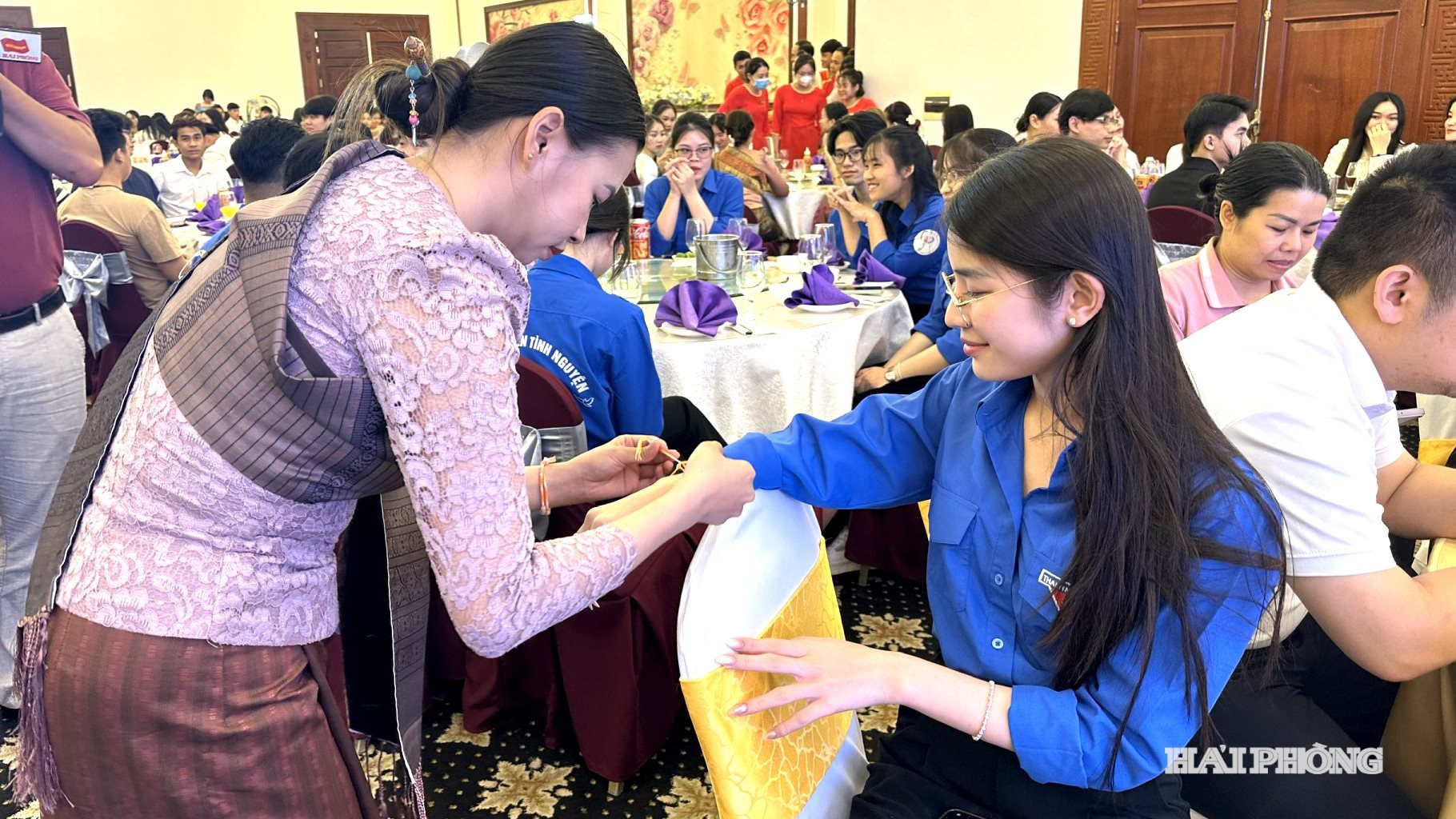 Sinh viên Lào buộc chỉ tay cho sinh viên Việt Nam tại Chương trình gặp mặt, giao lưu với sinh viên Lào đang học tập tại Hải Phòng nhân dịp Tết Bunpimay của Lào năm 2024.