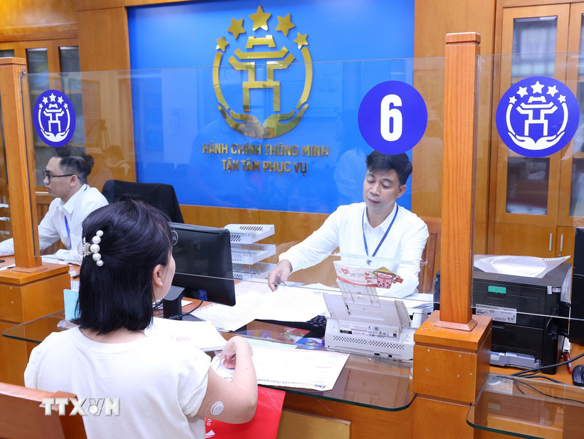 Người dân giải quyết thủ tục hành chính tại Trung tâm Phục vụ hành chính công Thành phố Hà Nội. (Ảnh: Văn Điệp/TTXVN)