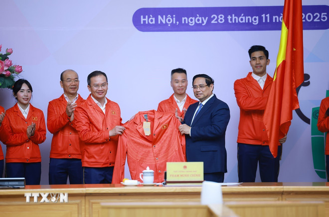 Đoàn thể thao Việt Nam tham dự SEA Games 33 trao tặng trang phục thi đấu cho Thủ tướng Phạm Minh Chính. (Ảnh: Dương Giang/TTXVN) ttxvn-thu-tuong-pham-minh-chinh-du-le-xuat-quan-doan-the-thao-viet-nam-tham-du-sea-games-33-8439229-10.jpg