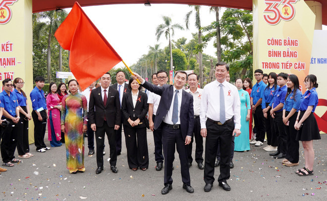 Giáo sư, Tiến sỹ Trần Văn Thuấn, Thứ trưởng Bộ Y tế vẫy cờ xuất phát diễu hành tuyên truyền phòng, chống HIV/AIDS. (Ảnh: Trung Tuyến/TTXVN) bo-y-te.jpg