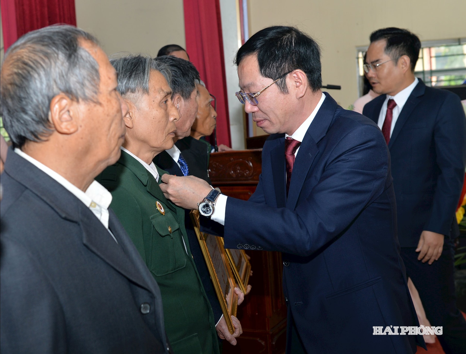 Đồng chí Vũ Tiến Phụng, Phó chủ tịch UBND thành phố phát gắn Huy hiệu Đảng tặng các đồng chí Đảng viên.