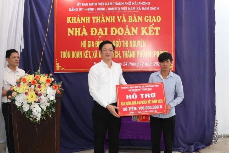 ẢNh báo in trang 1: Đồng chí Phạm Văn Lập, Phó bí thư Thành ủy, Chủ tịch Ủy ban MTTQ thành phố trao hỗ trợ xây nhà 