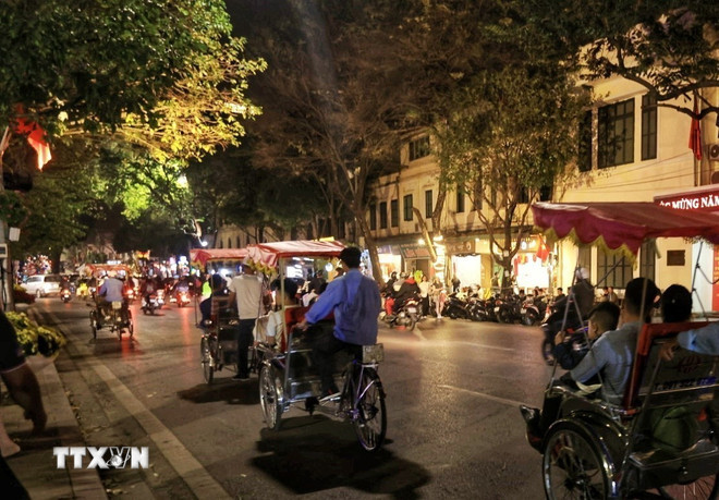 Du khách ngắm phố phường Hà Nội trên những chuyến xích lô. (Ảnh: Tuấn Anh/TTXVN) ttxvn-pho-co-ha-noi.jpg