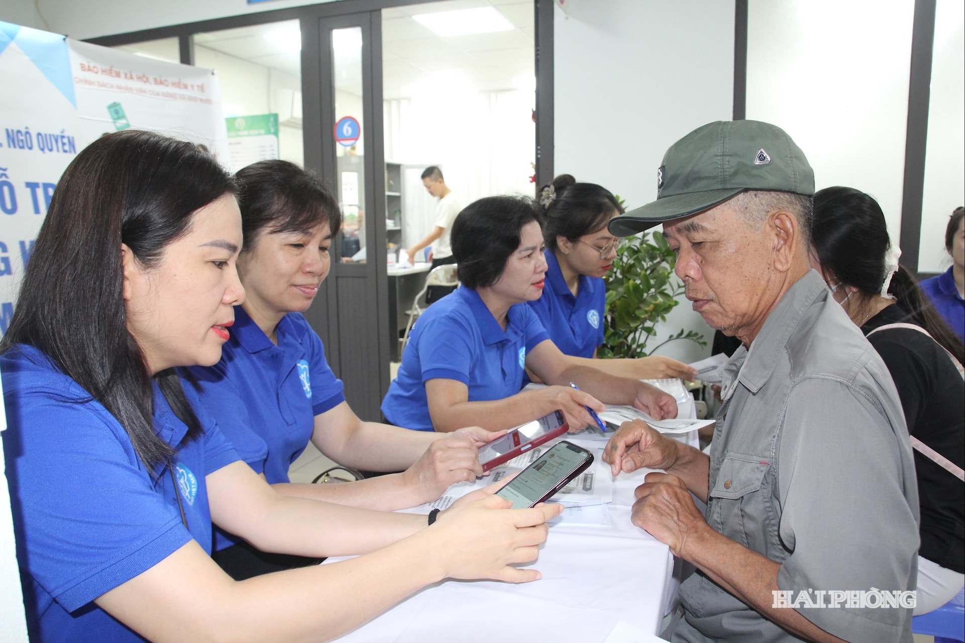 Cán bộ cơ quan Bảo hiểm xã hội hỗ trợ, hướng dẫn người dân cài đặt ứng dụng