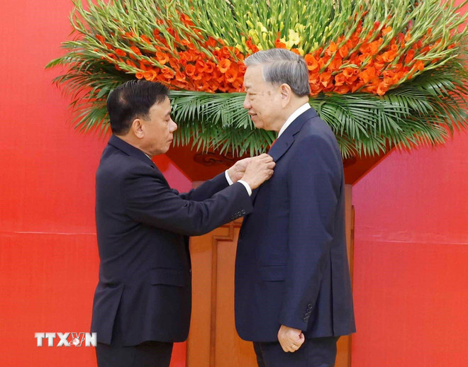 Đồng chí Trần Cẩm Tú, Ủy viên Bộ Chính trị, Thường trực Ban Bí thư trao Huy hiệu Đảng và tặng hoa chúc mừng Tổng Bí thư Tô Lâm. (Ảnh: Thống Nhất/TTXVN) ttxvn-le-trao-huy-hieu-45-nam-tuoi-dang-tang-tong-bi-thu-to-lam-03-1.jpg