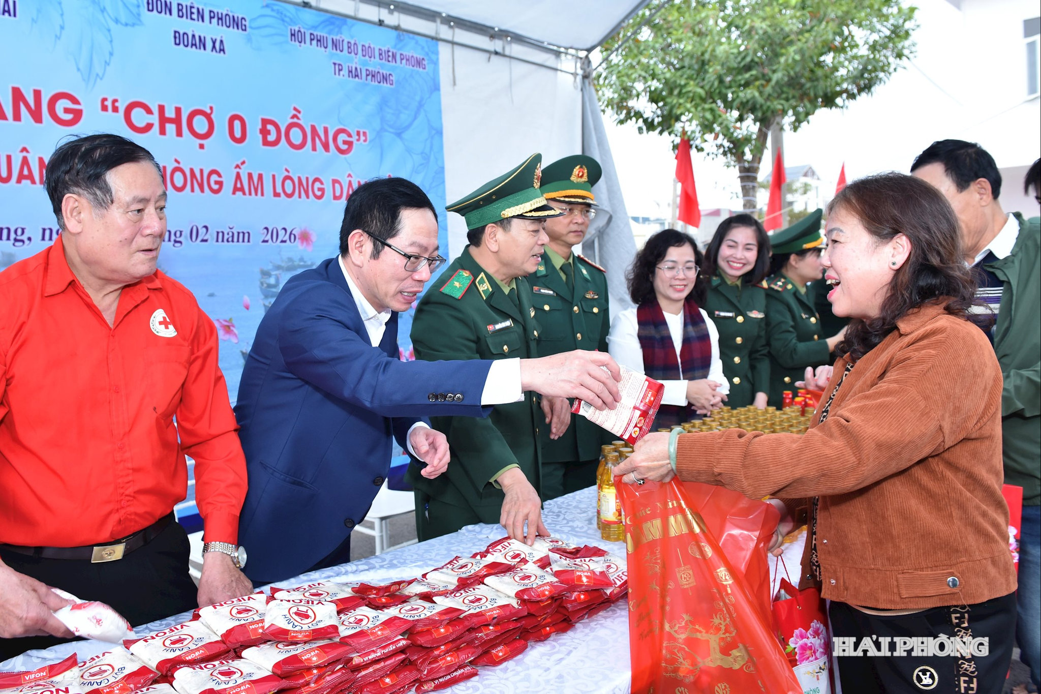 Các đồng chí: Thiếu tướng Nguyễn Văn Thiện, Phó Tư lệnh Bộ đội Biên phòng; Vũ Tiến Phụng, Uỷ viên Ban Thường vụ Thành uỷ, Phó chủ tịch UBND thành phố trao quà tặng các hộ tại Phiên chợ 0 đồng.