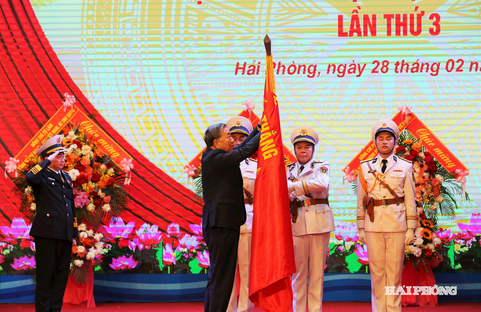 Tổng Bí thư Tô Lâm gắn Huy hiệu danh hiệu AHLLVTND lên quân kỳ quyết thắng và trao bằng danh hiệu Anh hùng LLVTND tặng QCHQ