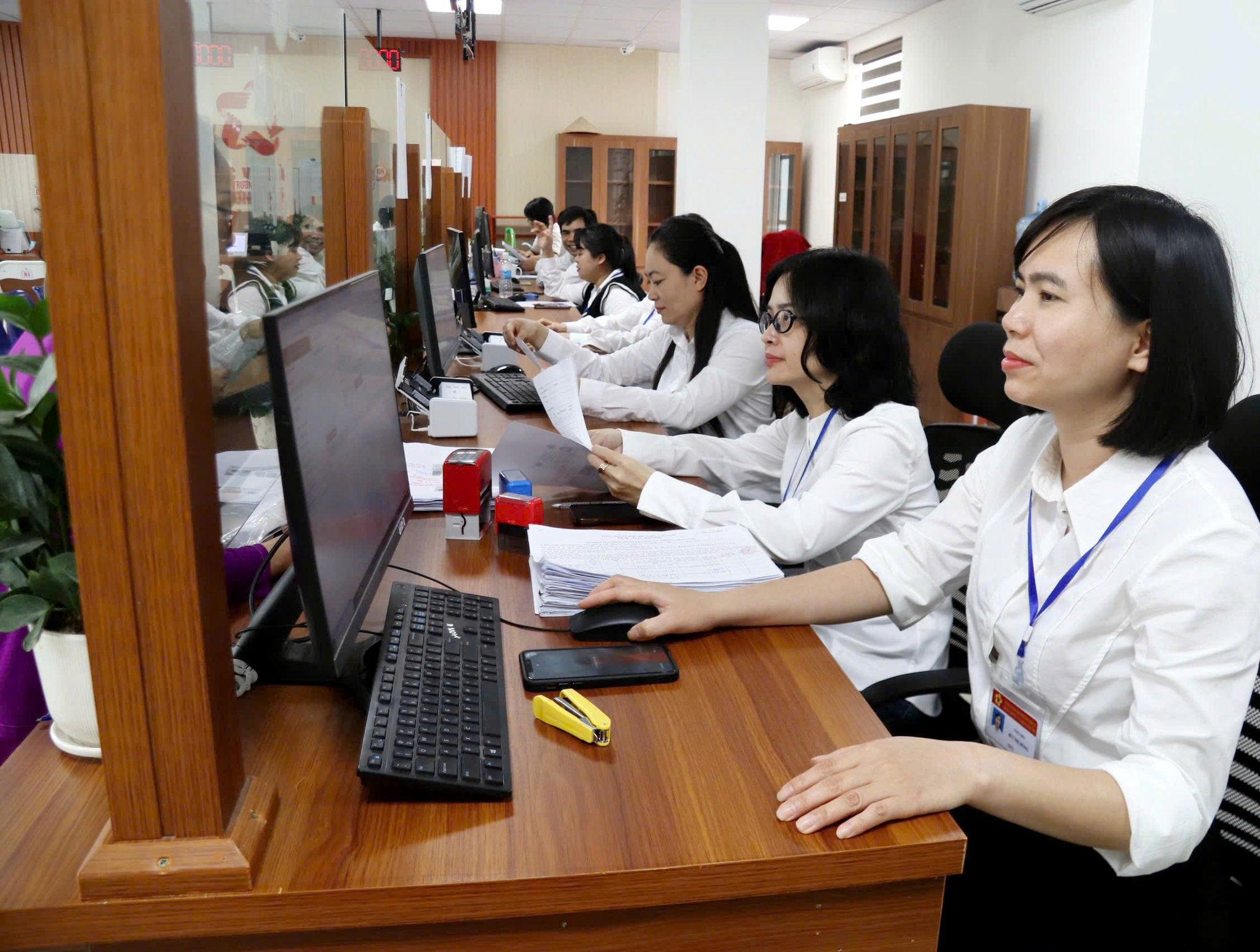 Các nhân viên nữ Trung tâm dịch vụ Hành chính công phường Hải An thực hiện nhiệm vụ giúp ng dân kê khai thủ tục hành chính.