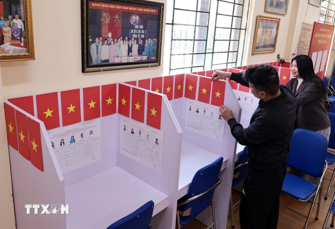 Chỉnh sửa vị trí cử tri viết phiếu bầu. (Ảnh: Trần Việt/TTXVN) ttxvn-bau-cu-ha-noi.jpg