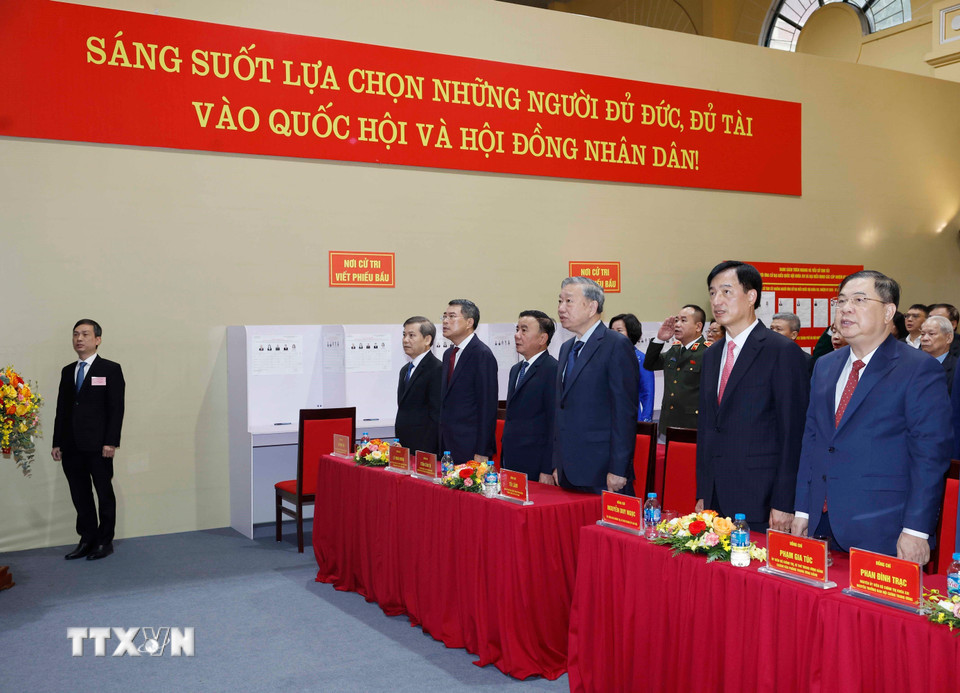 Tổng Bí thư Tô Lâm và các đại biểu cùng cử tri thực hiện nghi thức chào cờ, khai mạc bầu cử tại Khu vực bỏ phiếu số 02 phường Ba Đình, thành phố Hà Nội. (Ảnh: Thống Nhất/TTXVN)