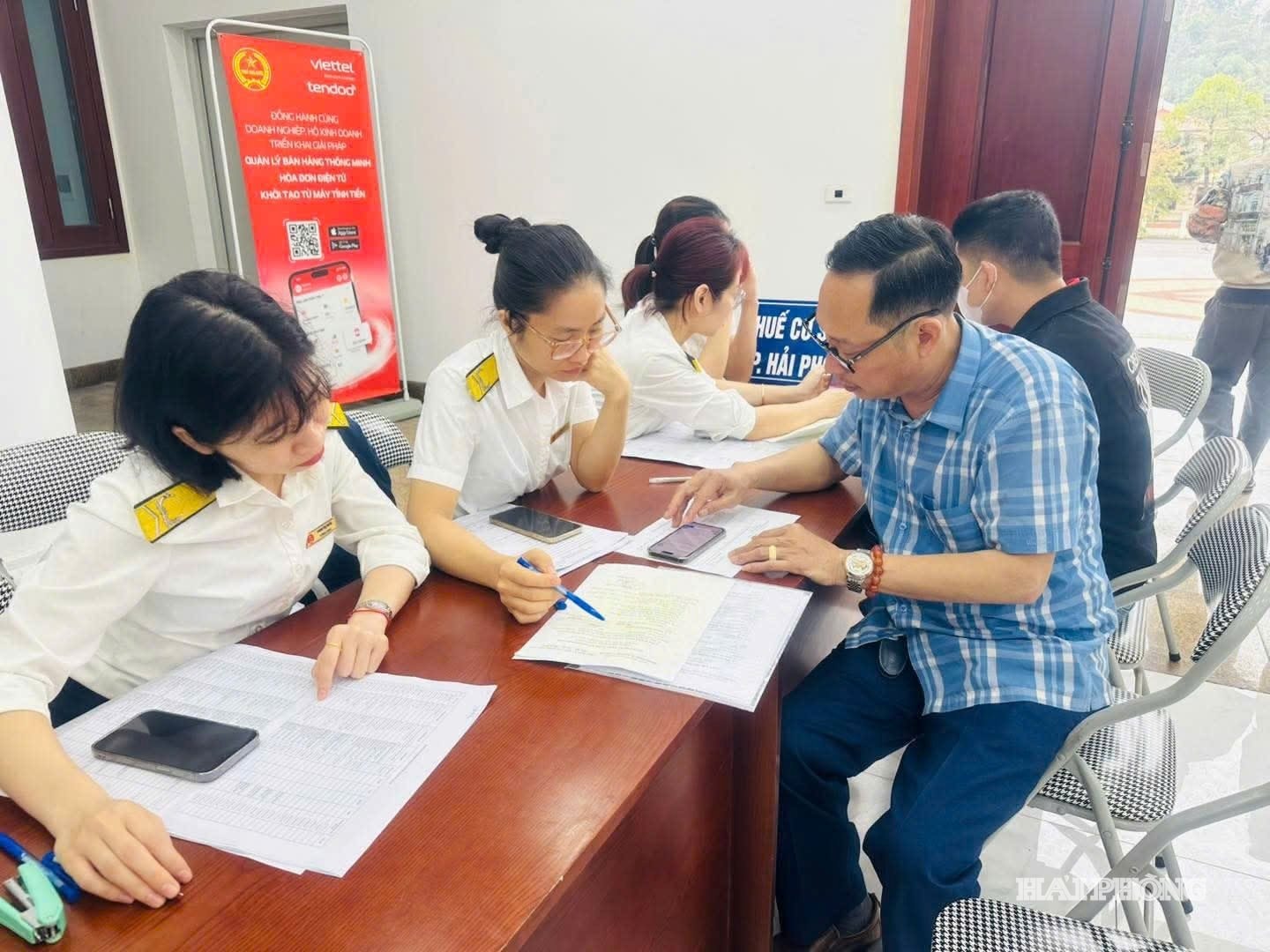 Cán bộ Thuế cơ sở 13 hỗ trợ hộ kinh doanh kê khai, nộp thuế.