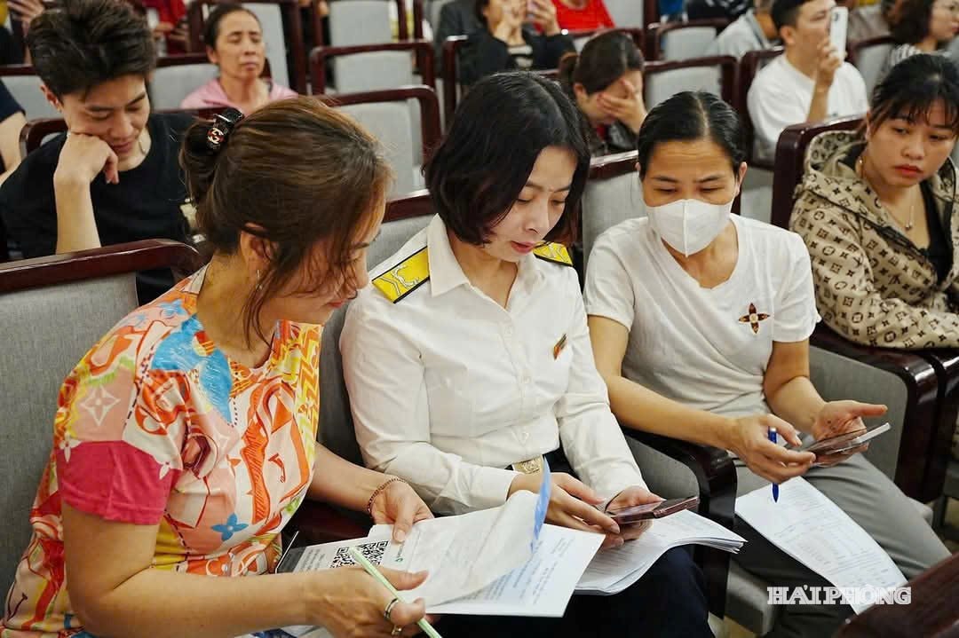 anh báo in: Cán bộ cơ sở thuế thành phố hướng dẫn hộ, cá nhân kinh doanh kê khai thuế.