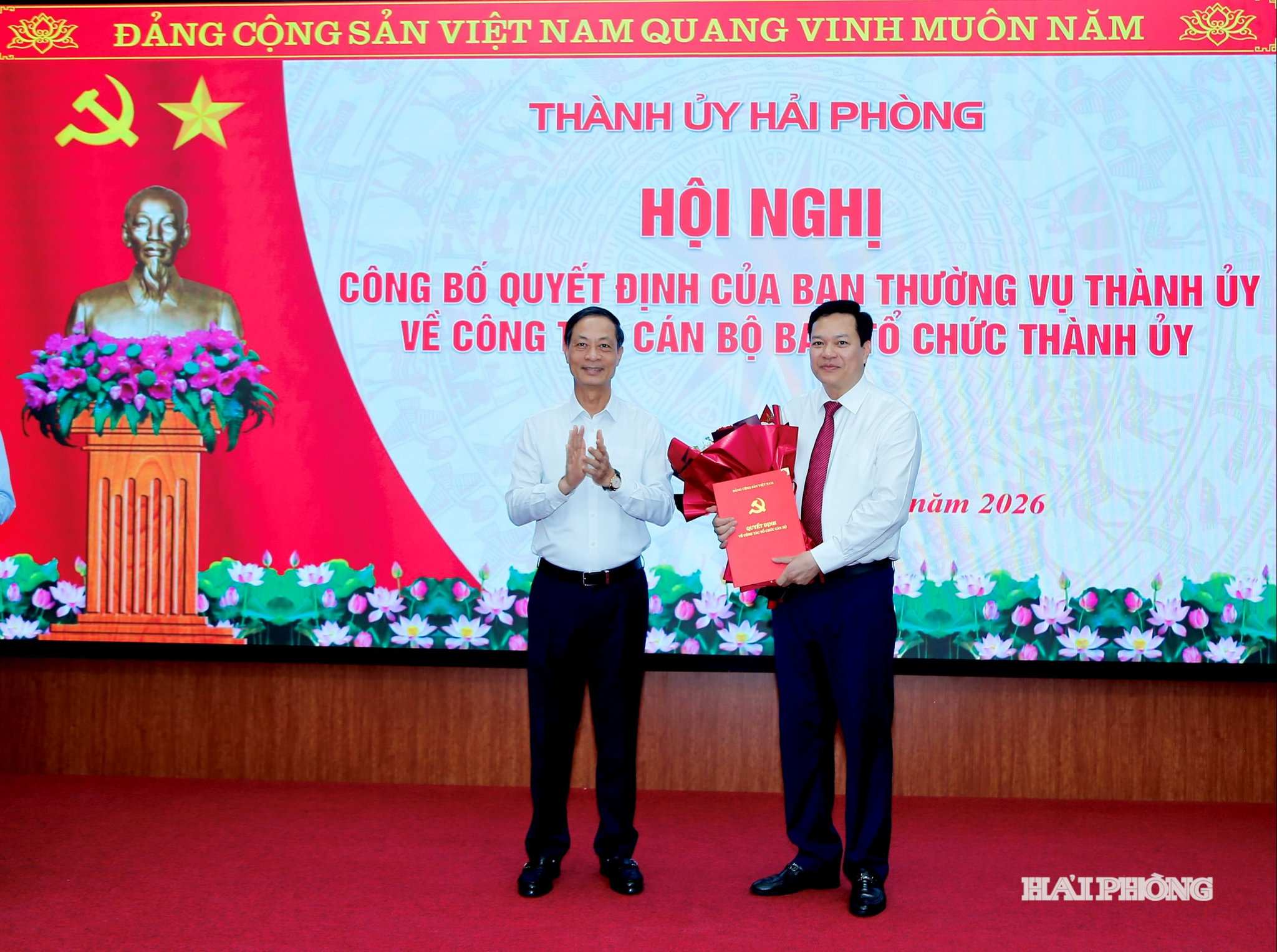 Đồng chí Đỗ Mạnh Hiến, Phó bí thư Thường trực Thành ủy trao Quyết định của ban Thường vụ Thành ủy và tặng hoa chúc mừng đồng chí Hoàng Văn Thực.
