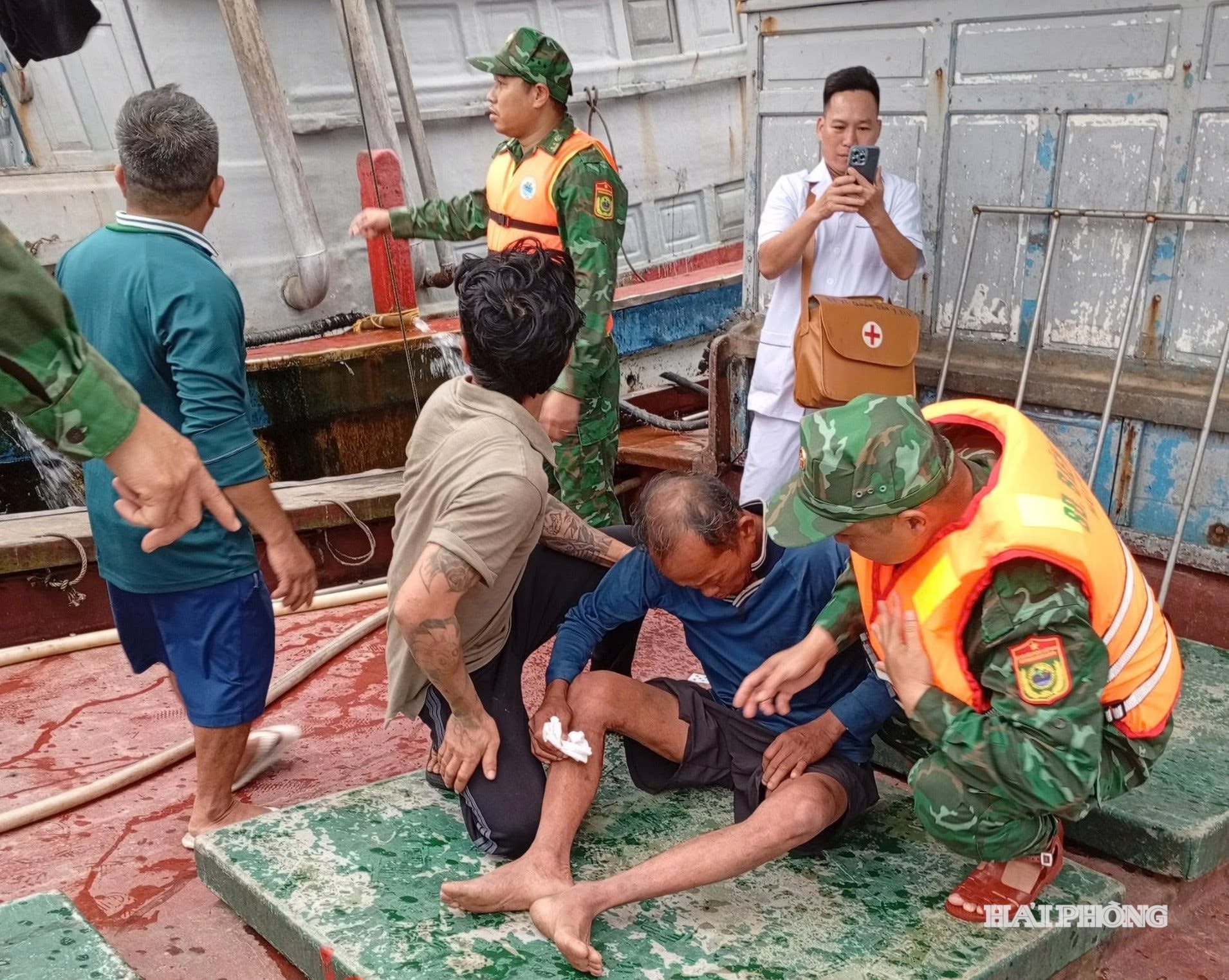 Cán bộ, chiến sĩ Đồn Biên phòng Bạch Long Vĩ và các y, bác sĩ Trung tâm Y tế quân dân y Bạch Long Vĩ sơ cứu cho ngư dân gặp nạn