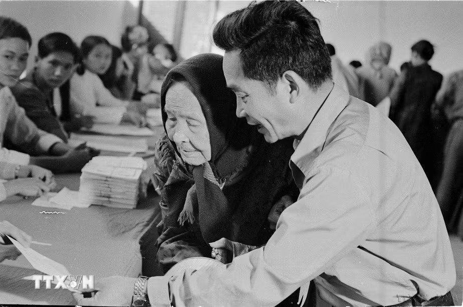 Ngày 25/4/1976, trên 23 triệu cử tri của nước Việt Nam thống nhất đã nô nức đi bầu cử. Đây thực sự là ngày hội lớn của toàn dân Việt Nam. Trong ảnh: Cụ Lê Thị Dưỡng (86 tuổi, thành phố Huế), già yếu vẫn nhờ người cõng đến hòm phiếu tham gia bầu cử đại biểu Quốc hội thống nhất (25/4/1976). (Ảnh: Sỹ Thái/TTXVN) ttxvn-50-nam-ngay-tong-tuyen-cu-bau-quoc-hoi-19.jpg