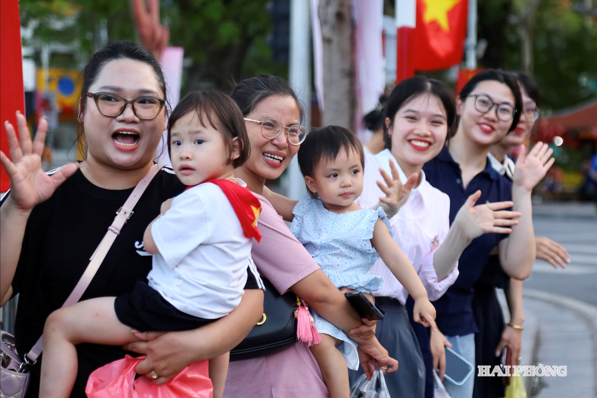 Các em nhỏ thích thú vẫy tay khi các đoàn nghệ thuật diễu hành qua trung tâm thành phố.