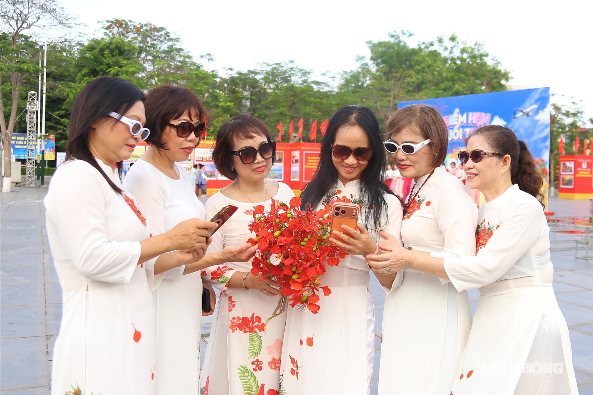 Hoang Huongs Gruppe aus dem Bezirk Le Chan traf am ersten Tag des Festivals früh ein, alle trugen traditionelle Ao Dai-Kleider und hielten Momente mit dem Symbol der Stadt der roten Flammenblumen fest.