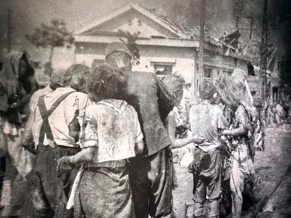 Những bức ảnh đen trắng tái hiện lại khung cảnh đổ nát của thành phố sau vụ ném bom, những mảnh quần áo rách nát, tất cả như những mảnh ghép đau buồn của quá khứ hiện về vô cùng chân thực. (Nguồn: Vietnam+)
