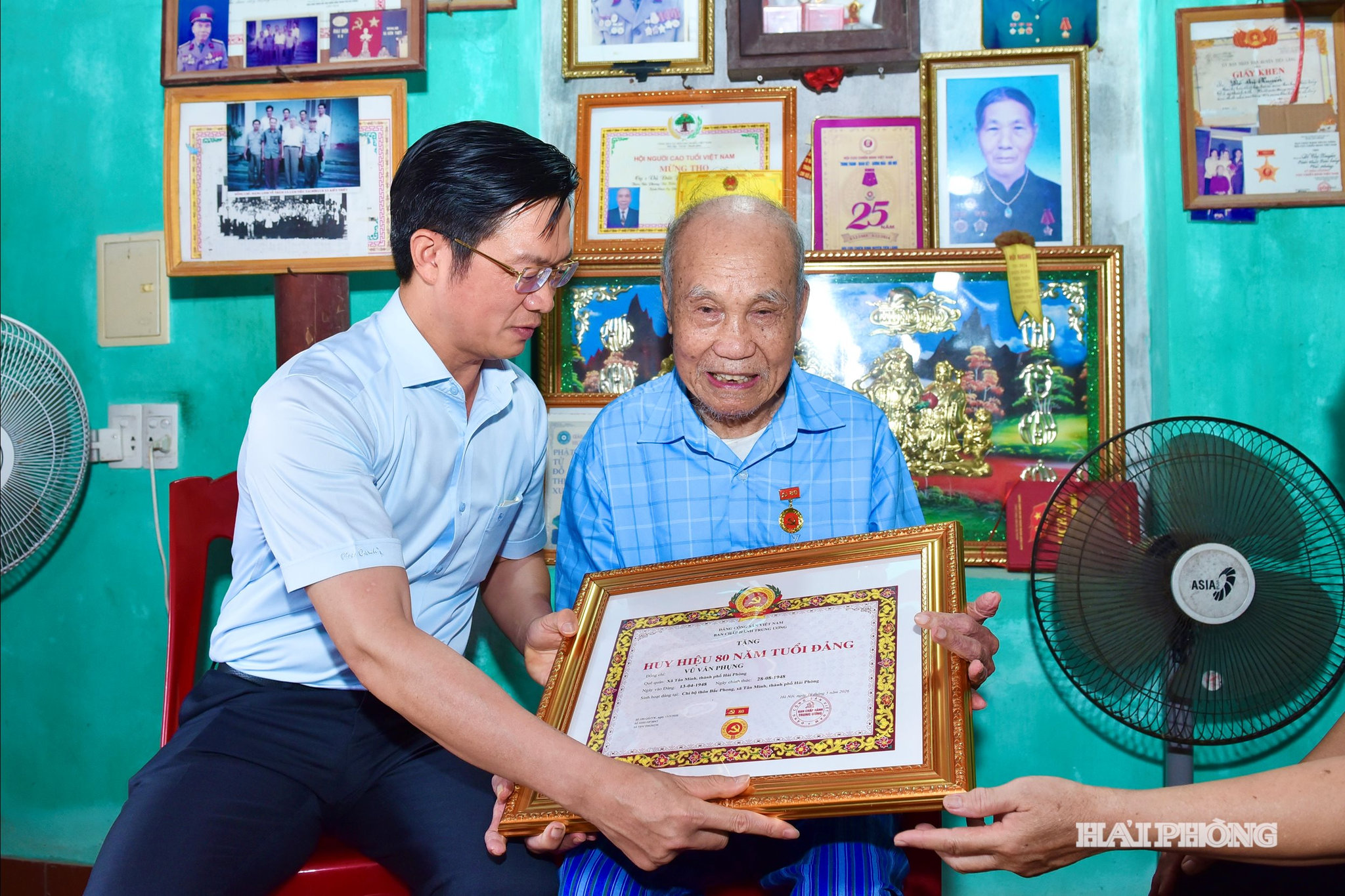 Đồng chí Phạm Văn Lập, Phó Bí thư Thành uỷ, Chủ tịch Uỷ ban MTTQ Việt Nam thành phố trao Huy hiệu 80 năm tuổi Đảng tặng đảng viên Vũ Văn Phụng.