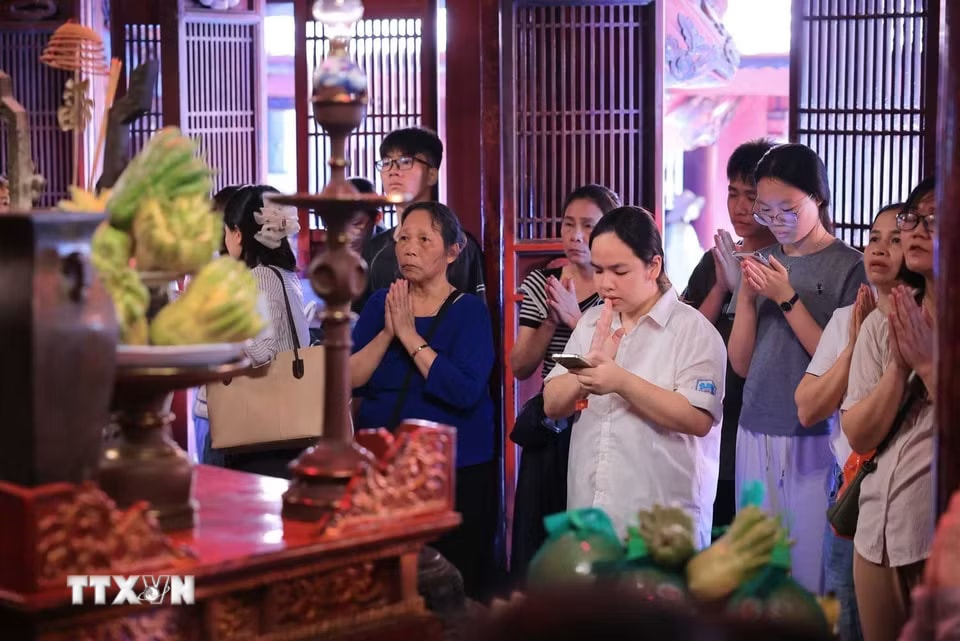 Nhiều phụ huynh và thí sinh đến Văn Miếu-Quốc Tử Giám nguyện cầu, mong việc học hành tấn tới, thi cử thuận lợi. (Ảnh: Hoàng Hiếu/TTXVN)