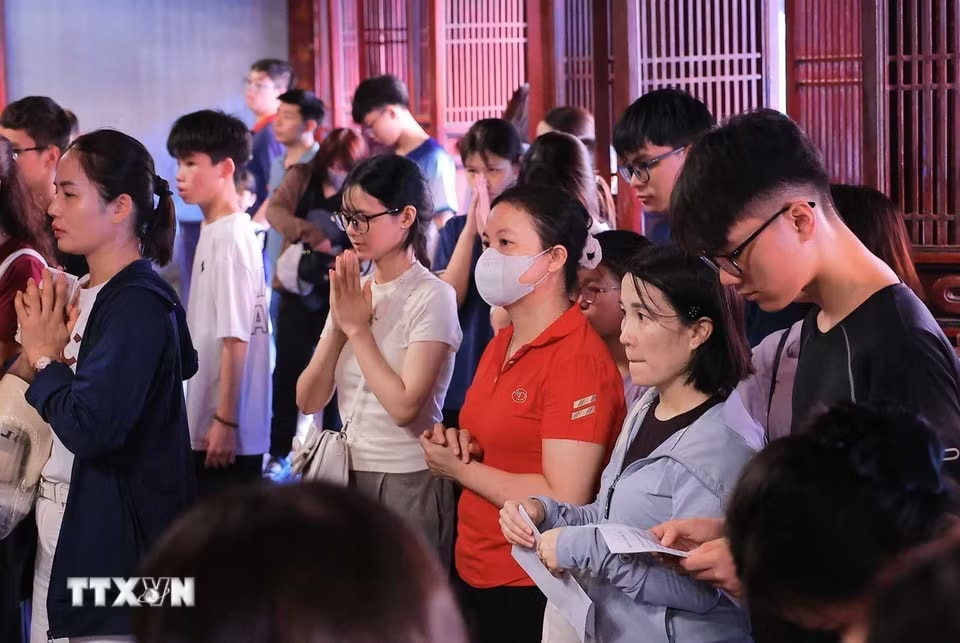 Nhiều phụ huynh và thí sinh đến Văn Miếu-Quốc Tử Giám nguyện cầu, mong việc học hành tấn tới, thi cử thuận lợi. (Ảnh: Hoàng Hiếu/TTXVN)