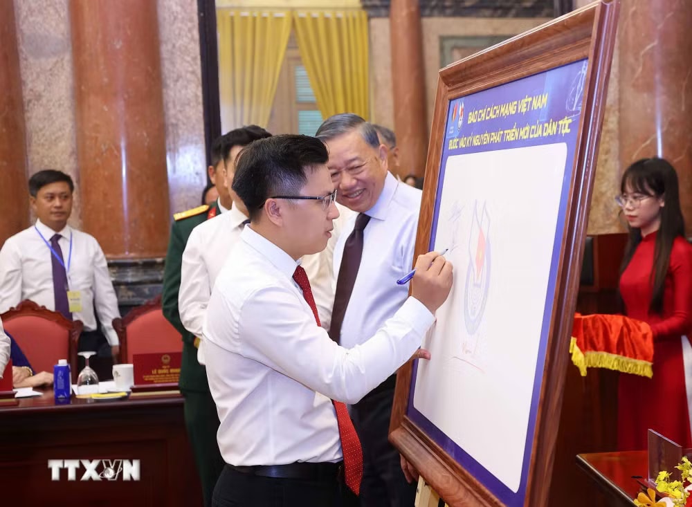 Các nhà báo tiêu biểu ký lưu niệm vào biểu trưng của Hội Nhà báo Việt Nam. (Ảnh: Văn Điệp/TTXVN) ttxvn-tong-bi-thu-chu-tich-nuoc-gap-mat-101-nha-bao-tieu-bieu-1.jpg