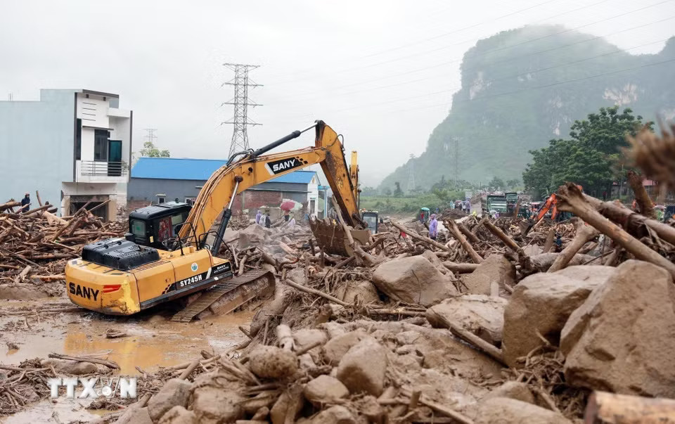Hàng ngàn mét khối đất đá đổ tràn xuống Quốc lộ 32 đang được lực lượng chức năng nỗ lực xử lý. (Ảnh: Quý Trung/TTXVN)