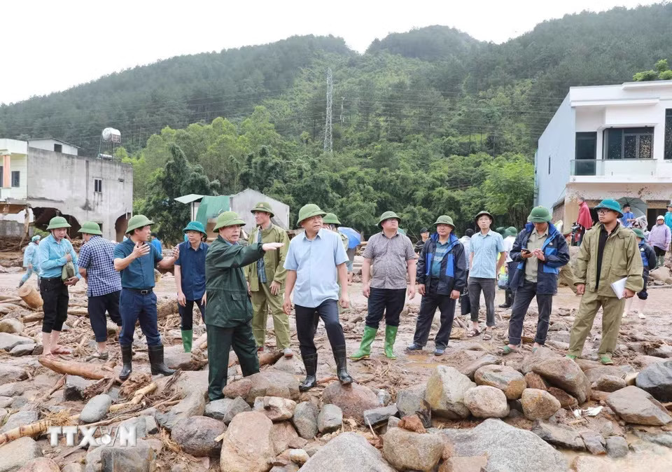 Chủ tịch Ủy ban Nhân dân tỉnh Lai Châu trao đổi với Thứ trưởng Nguyễn Hoàng Hiệp về sự việc lũ ống, lũ quét gây ra tại xã Mường Than, tỉnh Lai Châu. (Ảnh: Quý Trung/TTXVN)