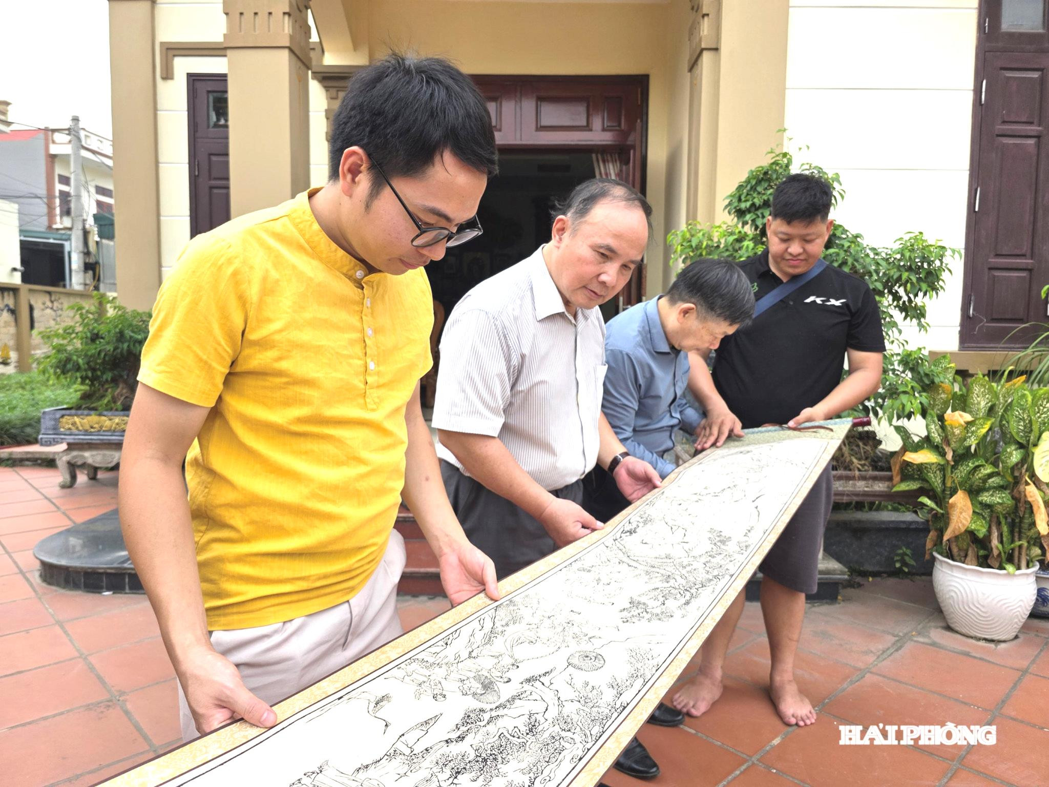Du khách từ thành phố Hà Nội chiêm ngưỡng bản in bức tranh.