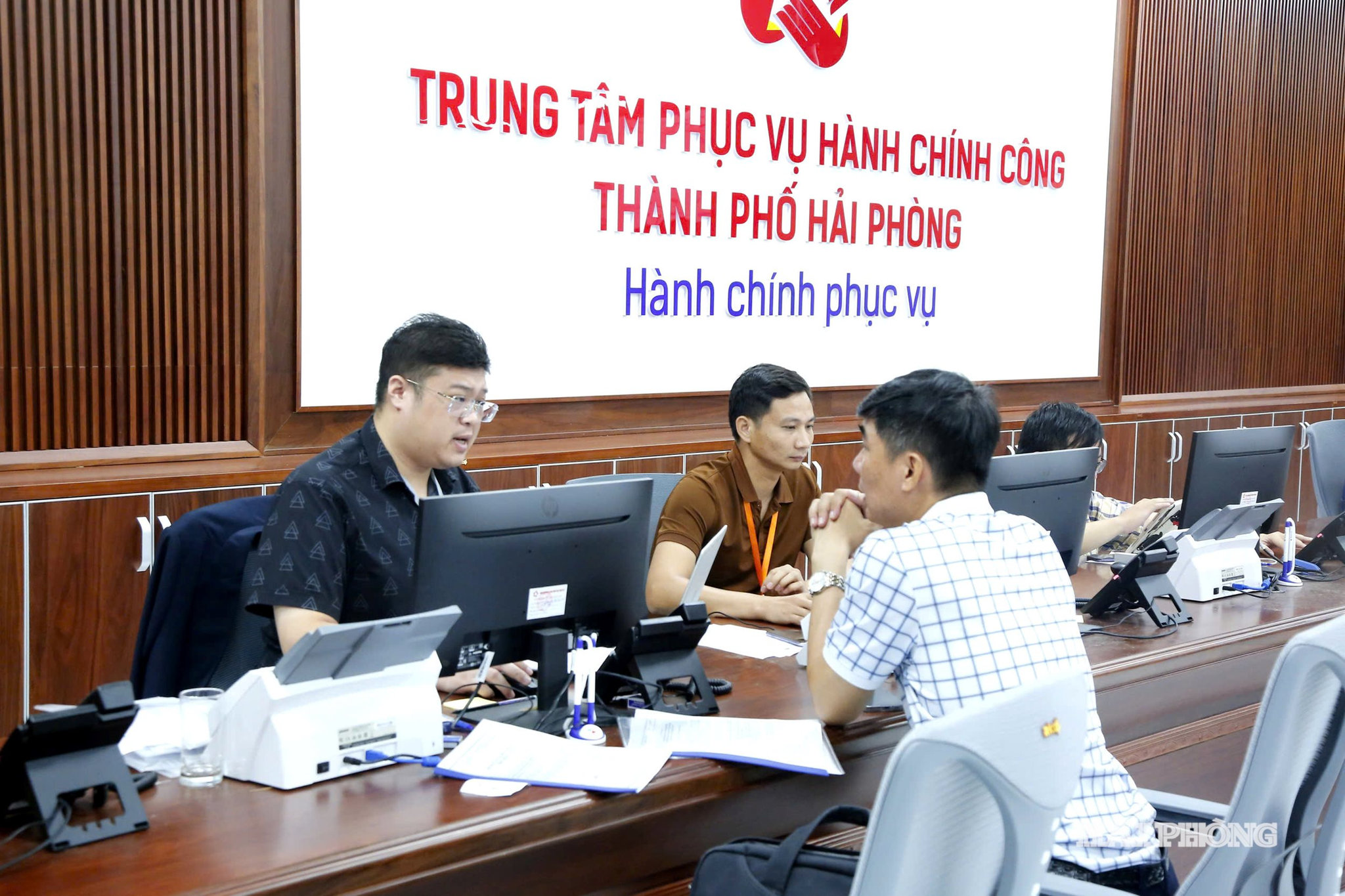 Cán bộ quầy tiếp nhận lĩnh vực văn hóa, thể thao và du lịch hướng dẫn, giải quyết thủ tục hành chính cho người dân tại Trung tâm Phục vụ hành chính công thành phố Hải Phòng. Ảnh ĐỖ HIỀN