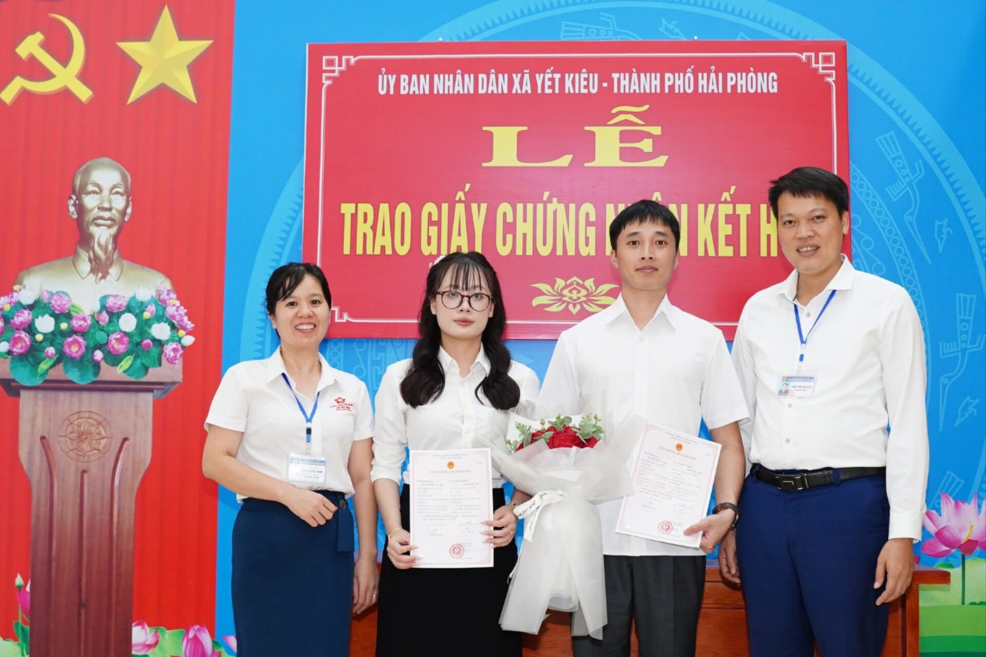 Ông Tăng Văn Nguyên, Phó Chủ tịch UBND xã Yết Kiêu tặng hoa chúc mừng và trao giấy đăng ký kết hôn cho công dân.