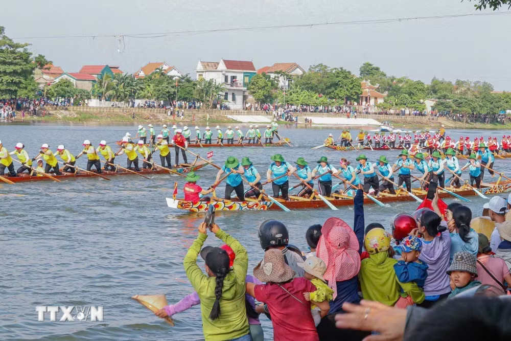 Người dân cổ vũ các đội thuyền đua nữ tại Lễ hội đua thuyền truyền thống trên sông Kiến Giang (Quảng Trị). Ảnh: TTXVN