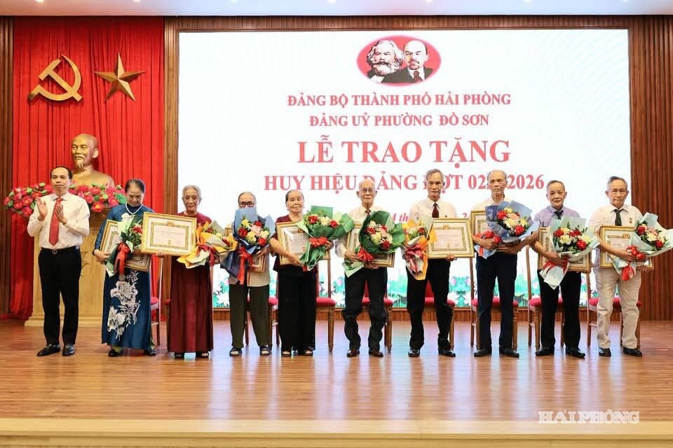 Đồng chí Lê Quốc Tiến, Bí thư Đảng ủy, Chủ tịch HĐND phường Đồ Sơn trao Huy hiệu đảng và tặng hoa chúc mừng các đảng viên thuộc Đảng bộ phường.