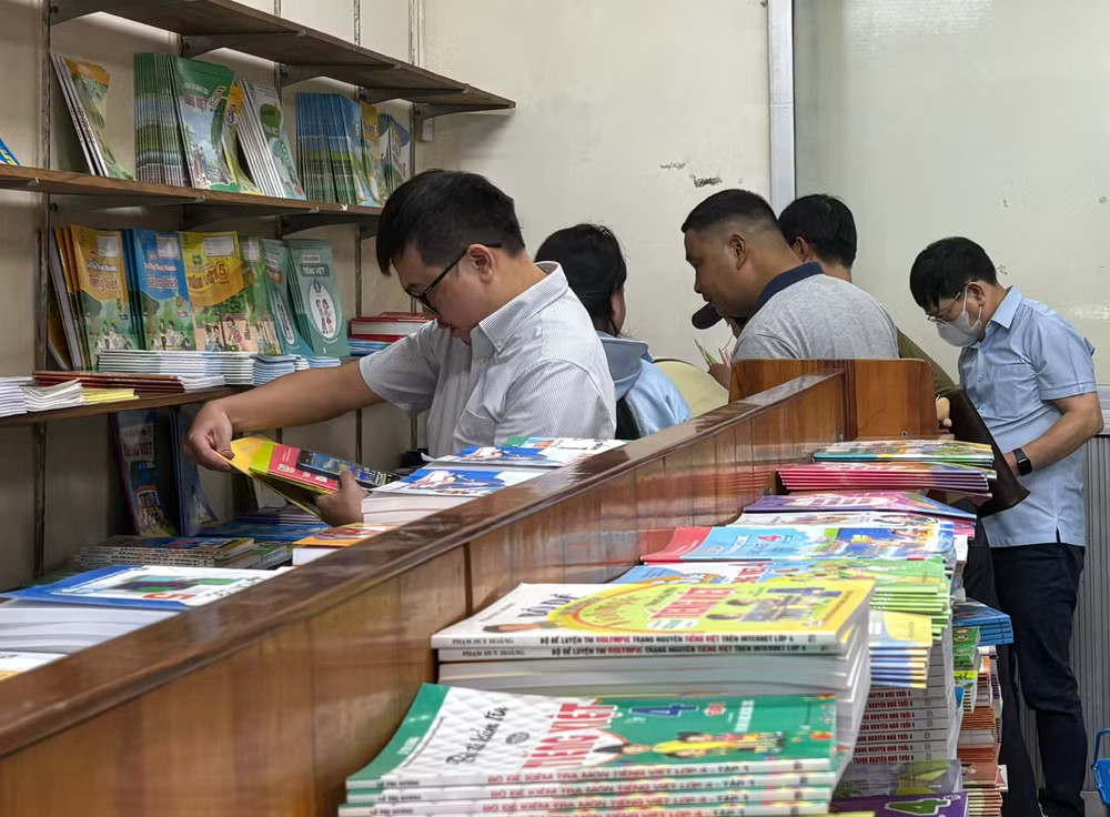 Phụ huynh tìm mua sách giáo khoa sau lễ khai giảng. (Ảnh: Phạm Mai/Vietnam+) faef3d44550ad5548c1b.jpg